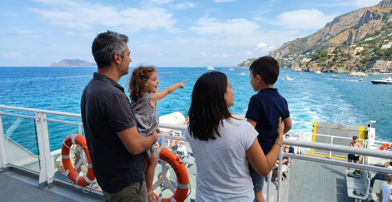 Una famiglia italiana con due bambini osserva il mare dal ponte di un traghetto moderno durante una giornata di sole